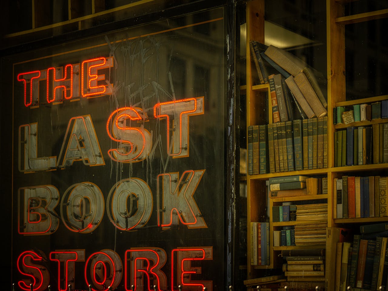 Vibrant neon sign of The Last Bookstore with a backdrop of books in Los Angeles.